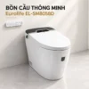 Bồn cầu màu trắng đóng nắp đặt cạnh tường, có màn hình phía sau và remote treo bên cạnh.