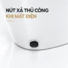 Cận cảnh chi tiết tròn màu đen phía dưới thân bồn cầu, được chú thích là nút xả thủ công khi mất điện.
